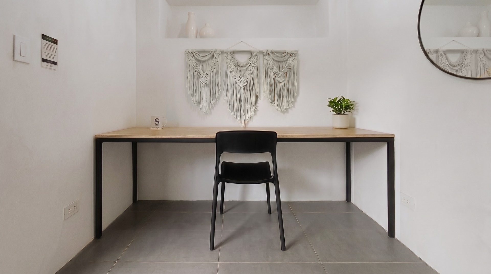 Clean private work studio with a centered chair and long wood desk